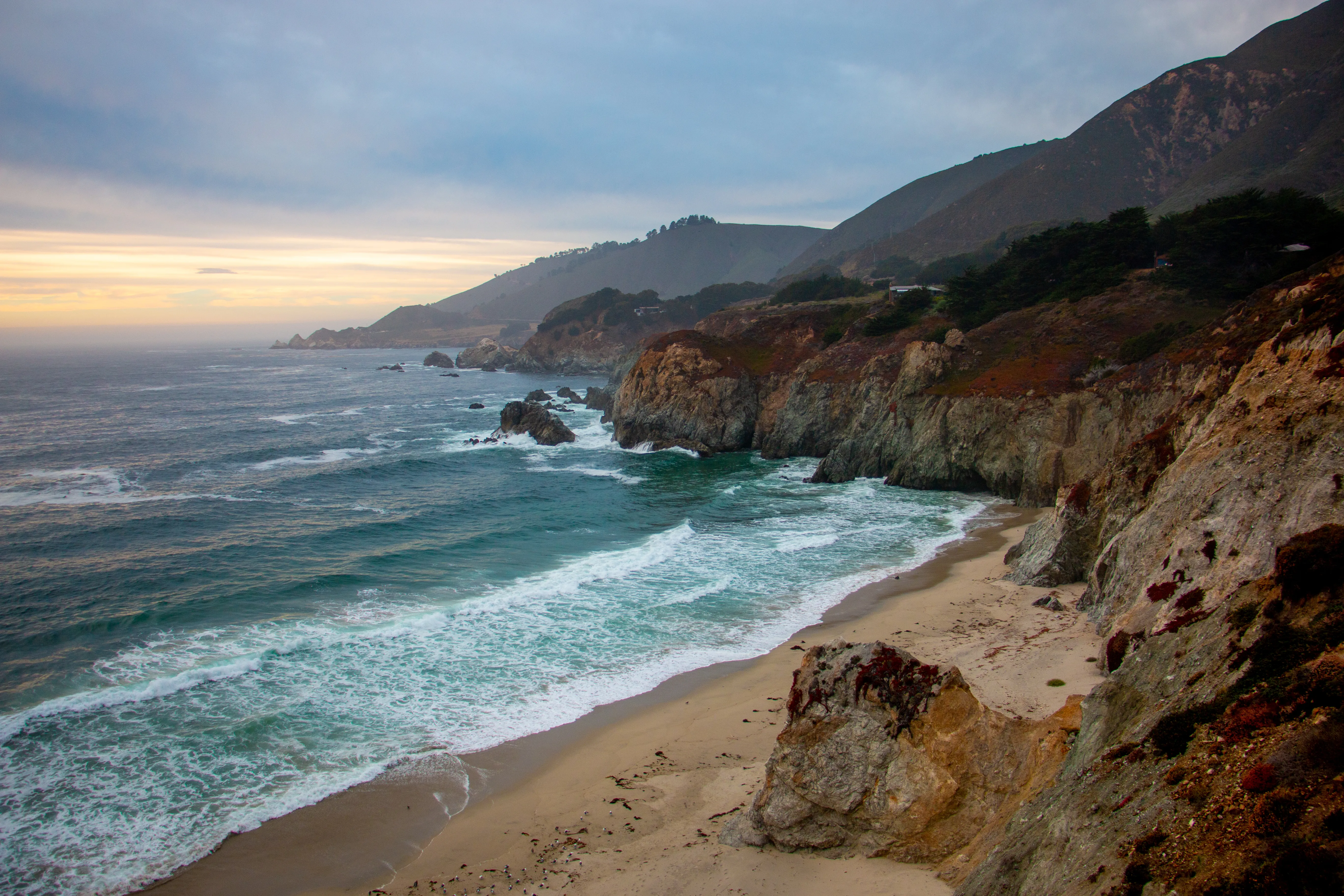Rocky coastline at sunset with waves below